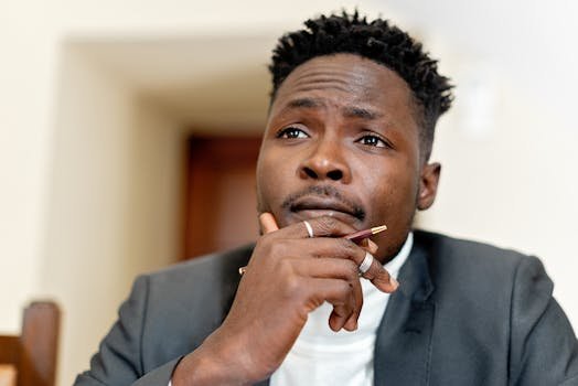 nutritions Close-up of a thoughtful businessman holding a pen, contemplating a decision indoors.